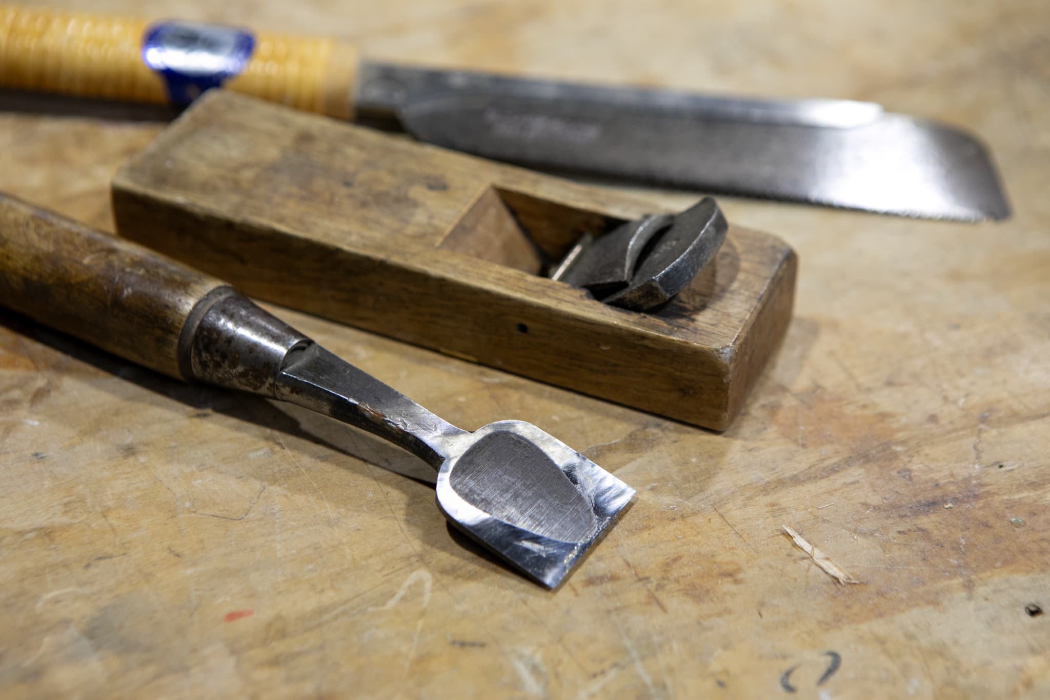 かんなで木材を削る作業員