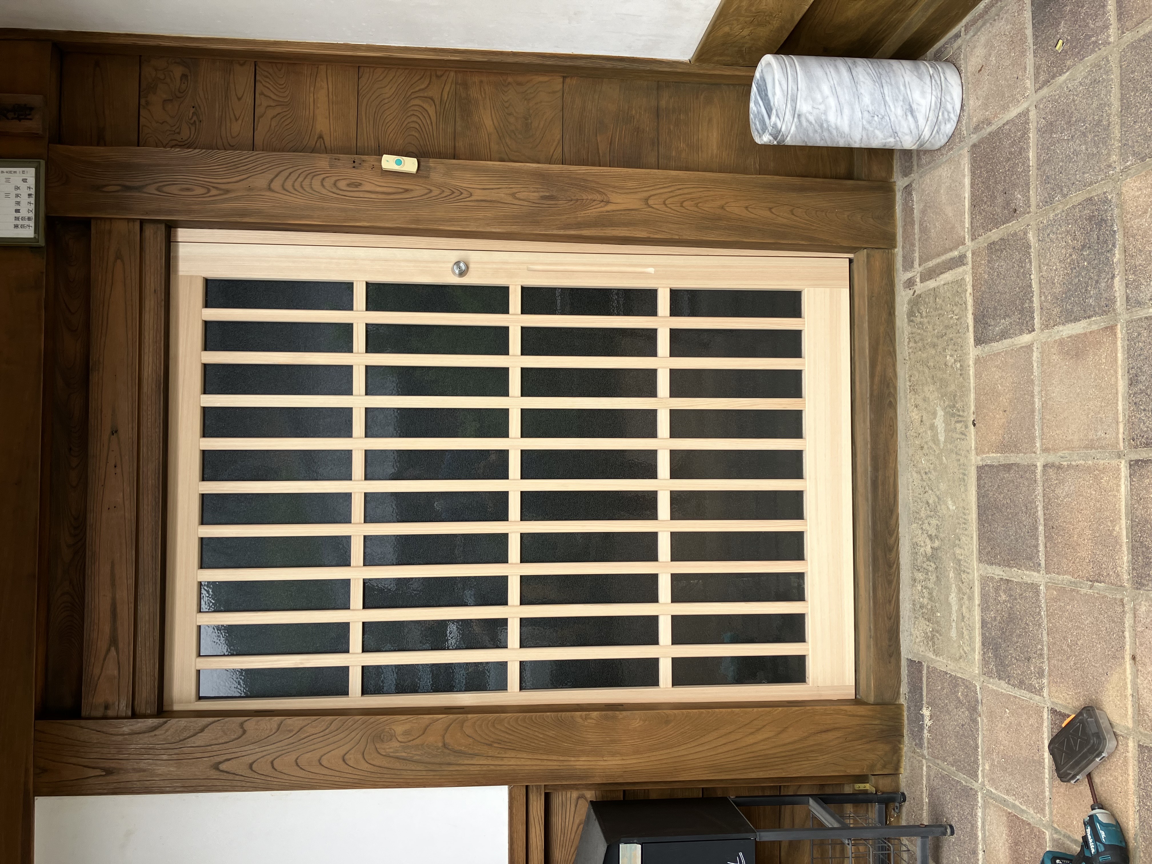 木目のタイルを貼る男性