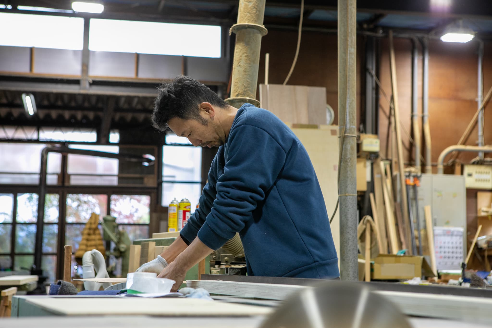 木目のタイルを貼る男性