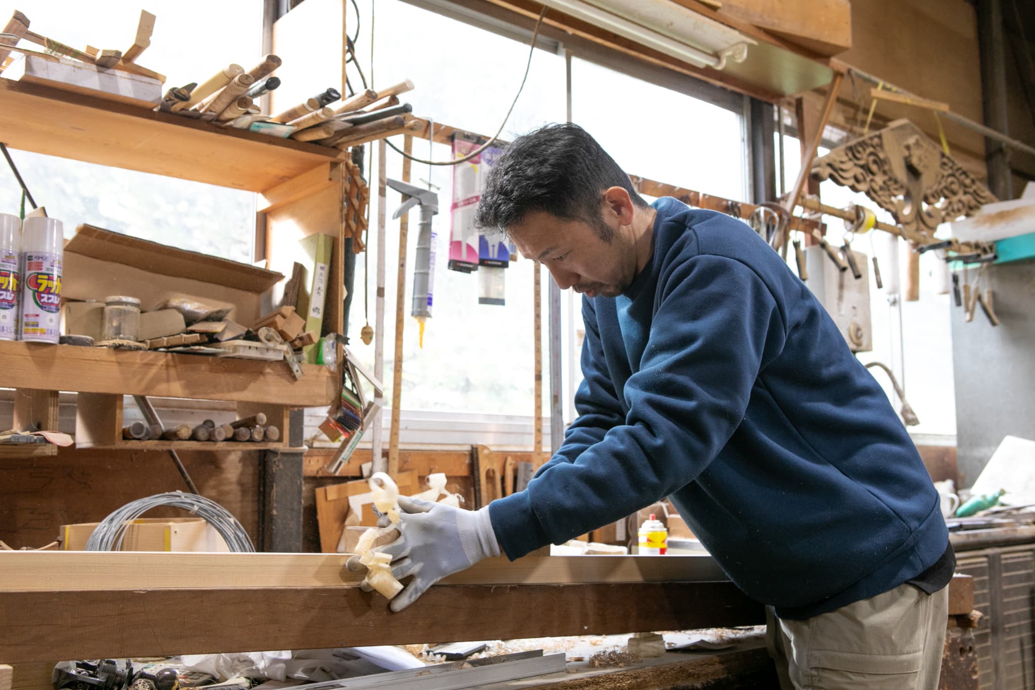 木目のタイルを貼る男性