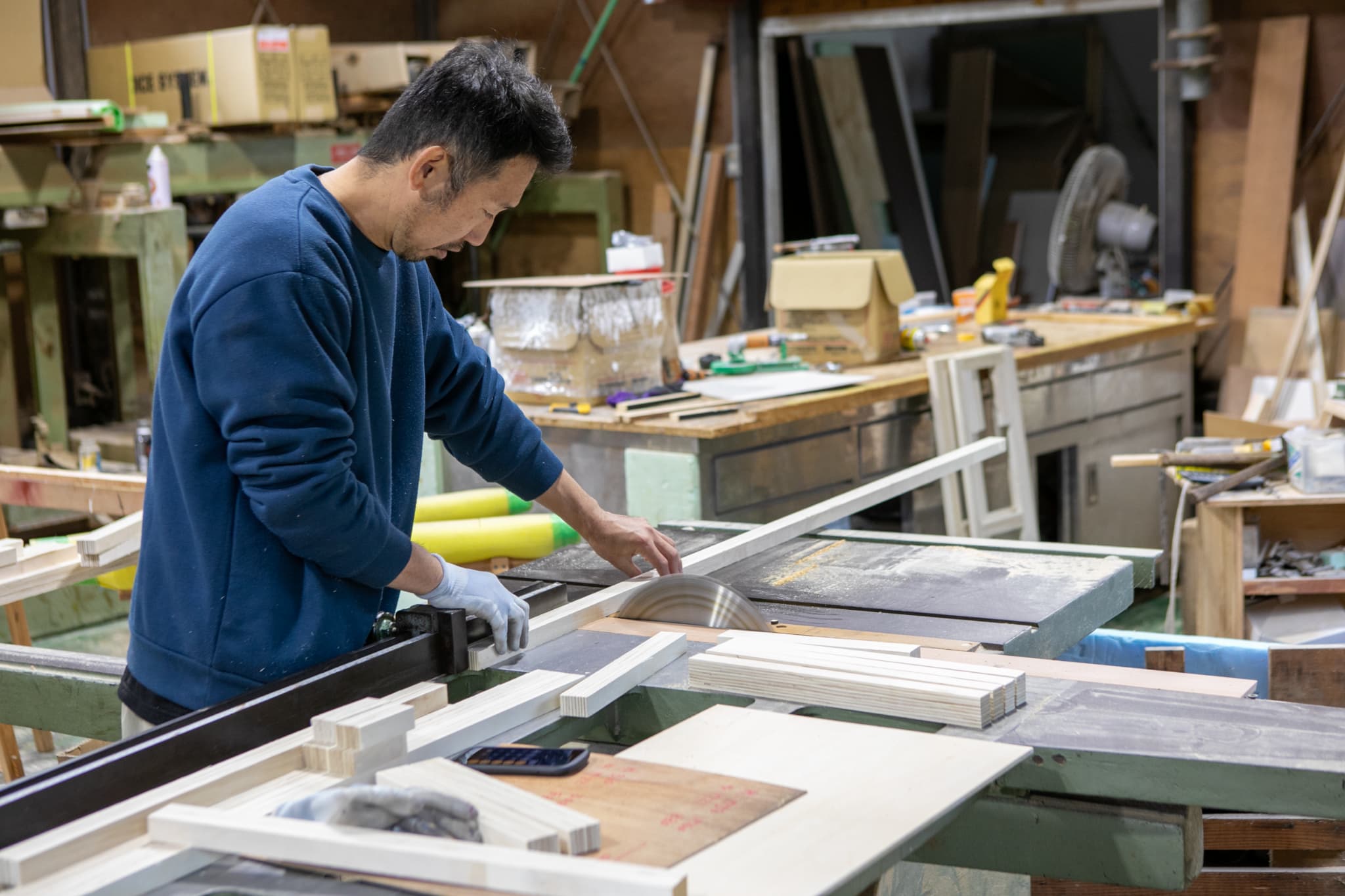 木目のタイルを貼る男性