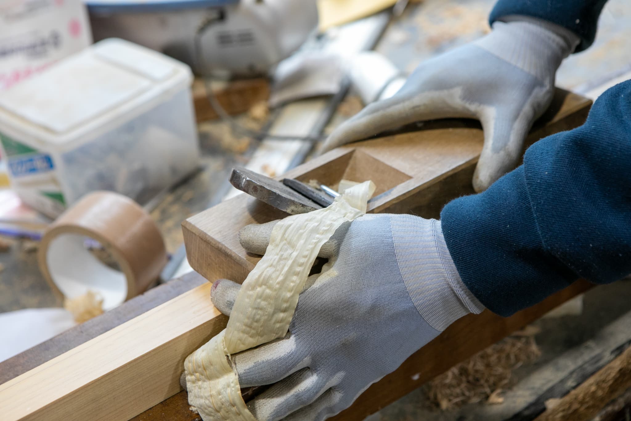 かんなで木材を削る作業員