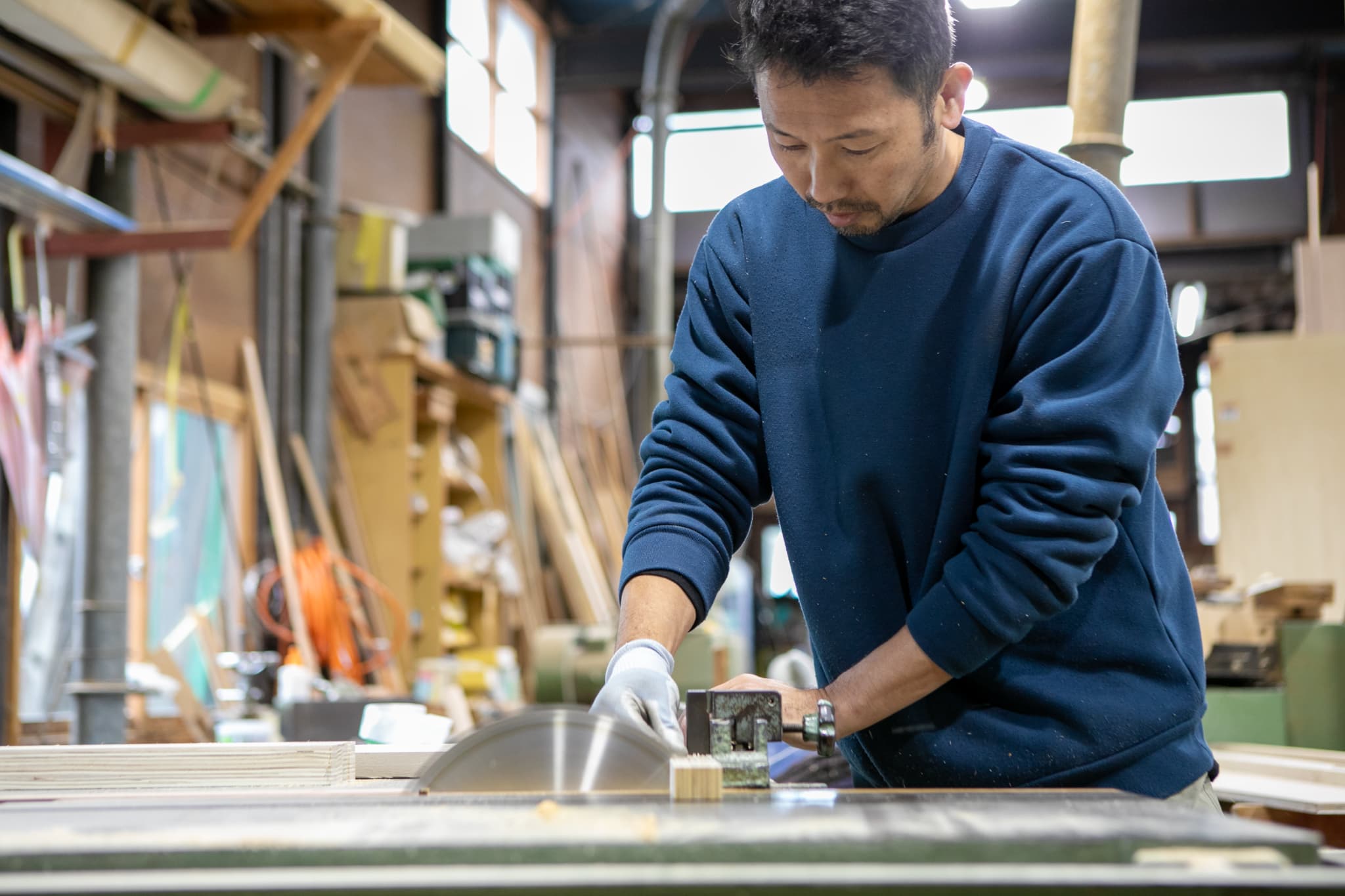 木目のタイルを貼る男性